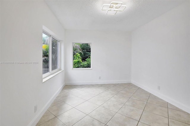 unfurnished room with light tile patterned floors and a textured ceiling