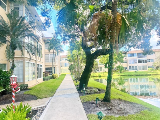 view of property's community with a water view and a yard