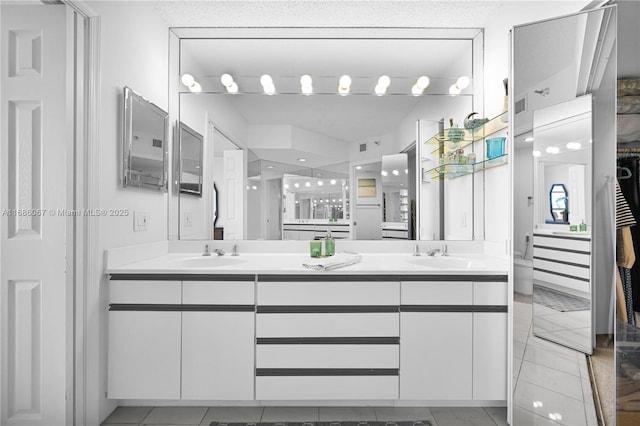 bathroom with double vanity, a sink, and tile patterned floors