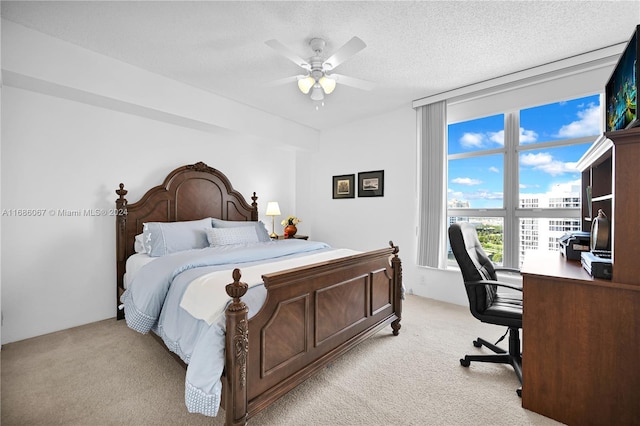 carpeted bedroom with ceiling fan and a textured ceiling