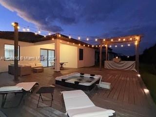 rear view of house featuring an outdoor hot tub, a wooden deck, and outdoor lounge area