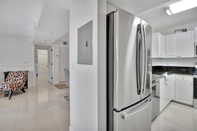 kitchen with electric panel, white cabinets, light tile patterned floors, and appliances with stainless steel finishes