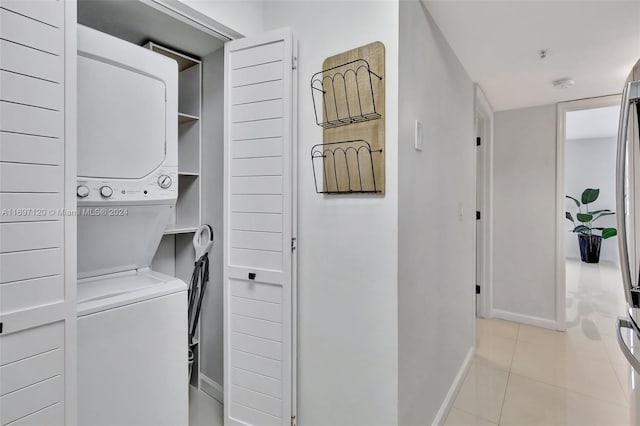 laundry area featuring light tile patterned floors and stacked washer / drying machine