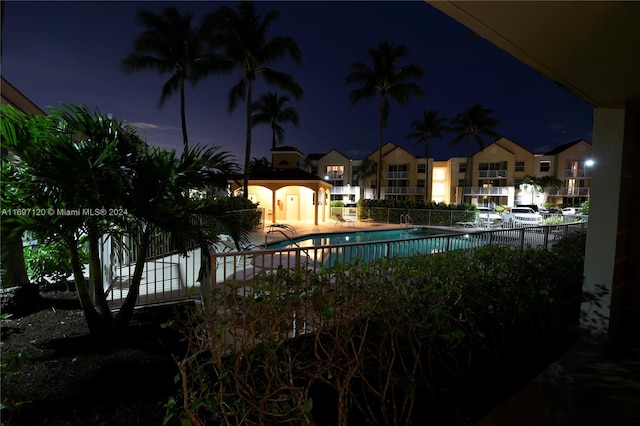 pool at twilight featuring a patio area