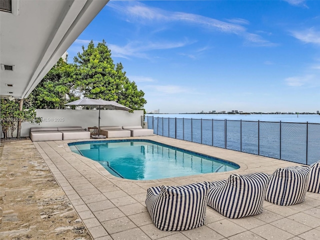 view of swimming pool featuring a water view and a patio area