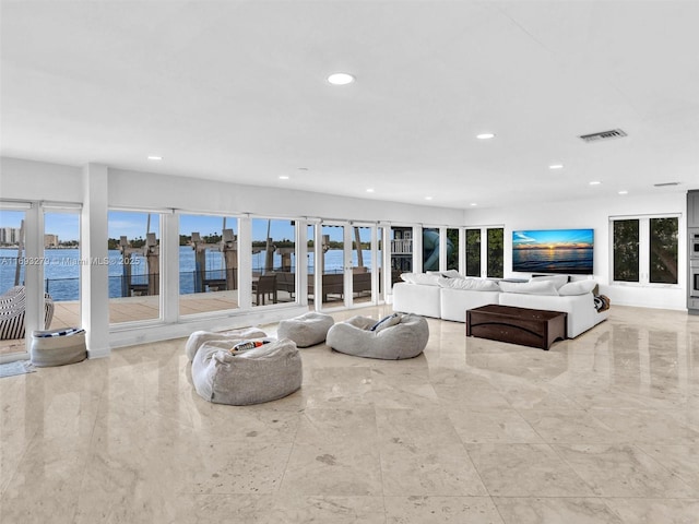 living room featuring plenty of natural light, a water view, and french doors