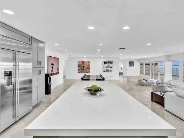 kitchen featuring a large island, gray cabinets, and stainless steel built in refrigerator