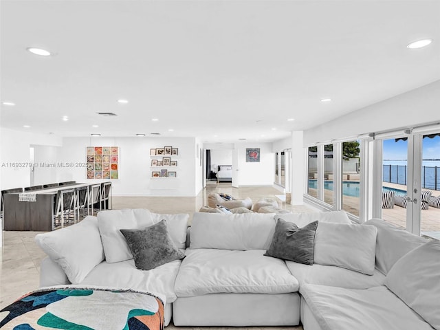 living room with french doors and a water view