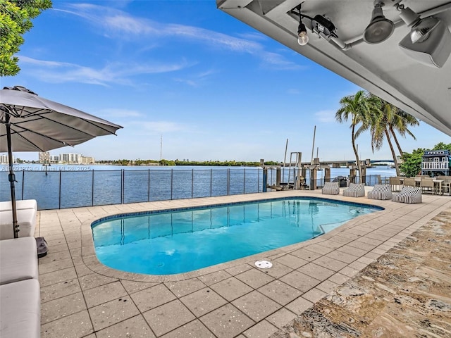 view of swimming pool featuring a patio and a water view