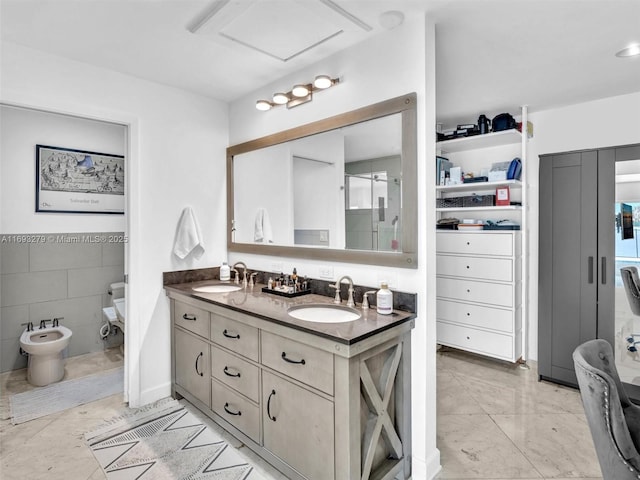 bathroom featuring vanity, a bidet, and tile walls