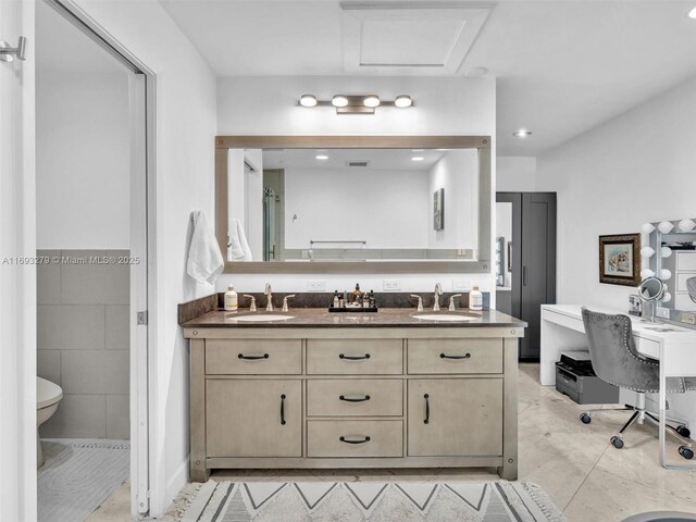 bathroom with tile patterned floors, vanity, toilet, and tile walls