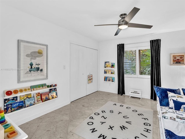 tiled bedroom featuring ceiling fan and a closet