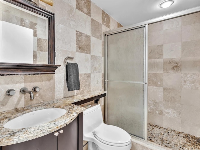 bathroom with vanity, an enclosed shower, tile walls, and tasteful backsplash