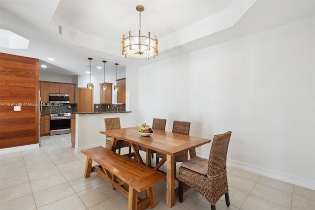 dining room featuring crown molding, a tray ceiling, a chandelier, and light tile patterned floors