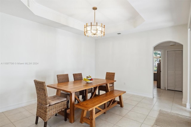 tiled dining room featuring crown molding, a notable chandelier, and a tray ceiling