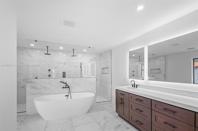 bathroom with shower with separate bathtub, vanity, and tile walls