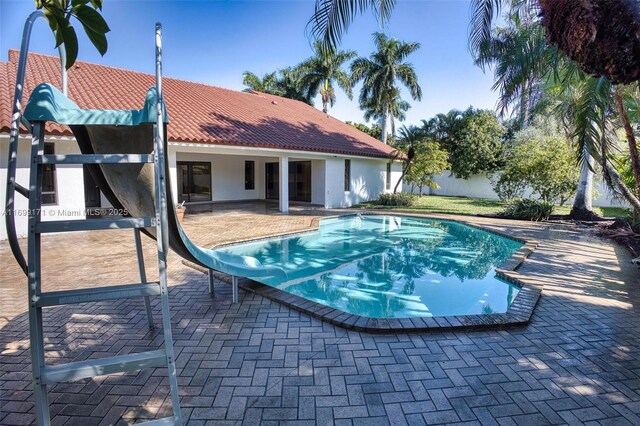 view of pool featuring a patio area and a water slide