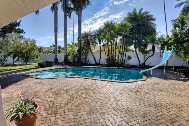 view of pool with a patio and a water slide