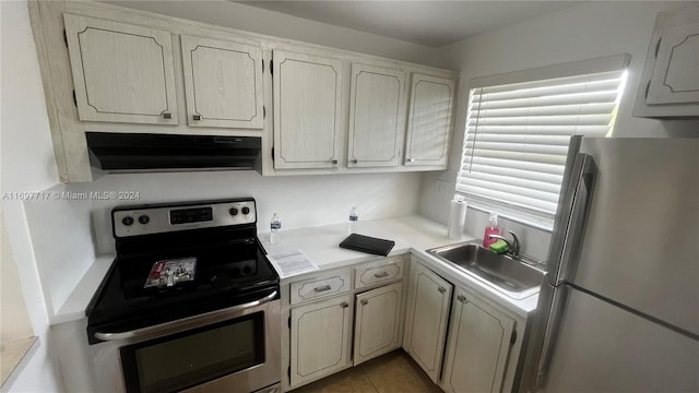 kitchen with sink, light tile patterned floors, stainless steel appliances, and exhaust hood