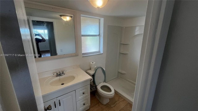 bathroom with tile patterned floors, vanity, toilet, and walk in shower