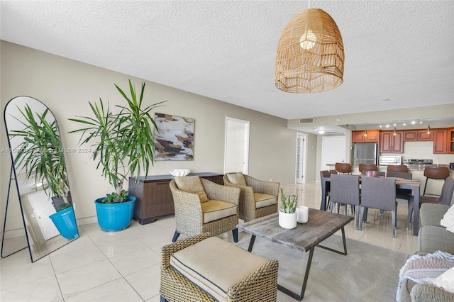 living room with light tile patterned flooring and a textured ceiling