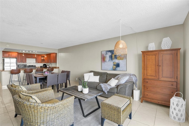 living room with a textured ceiling and light tile patterned flooring