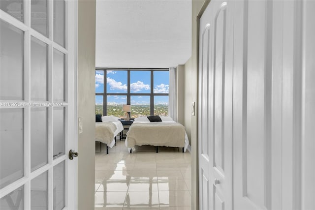 bedroom with light tile patterned floors and expansive windows