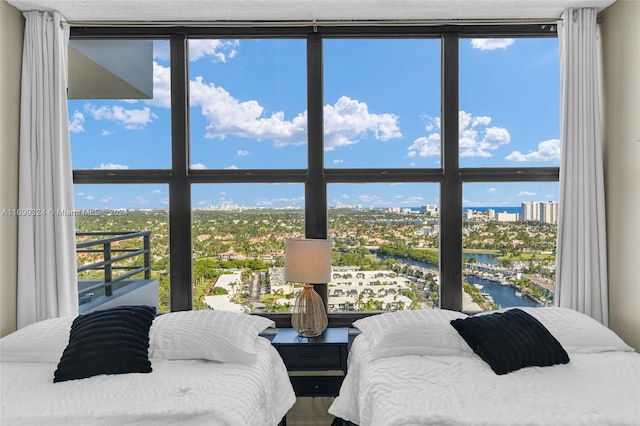 bedroom with a water view and floor to ceiling windows