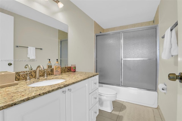 full bathroom featuring tile patterned flooring, vanity, toilet, and combined bath / shower with glass door