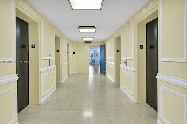 corridor with elevator and light tile patterned floors