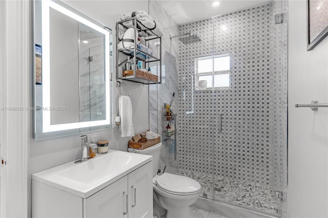 bathroom featuring vanity, toilet, and a shower with door