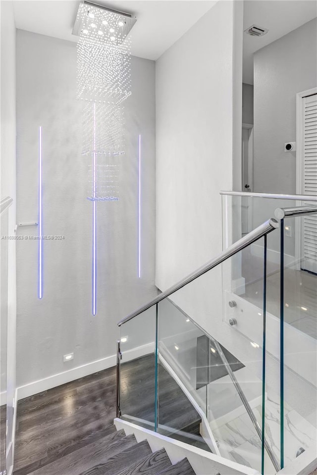 stairway featuring a notable chandelier and hardwood / wood-style flooring