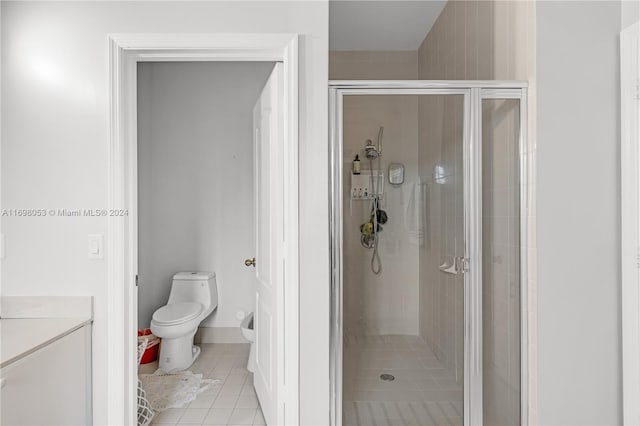 bathroom with tile patterned flooring, washer / clothes dryer, toilet, a shower with door, and vanity