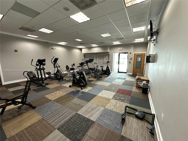 workout area with carpet flooring and a paneled ceiling