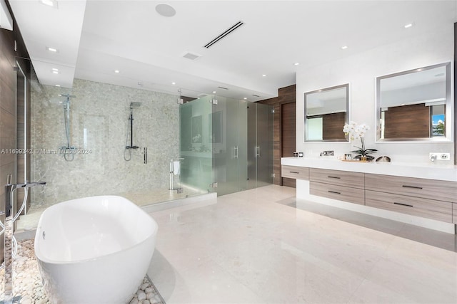 bathroom with independent shower and bath, vanity, and tile walls