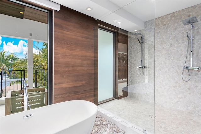 bathroom featuring plenty of natural light and independent shower and bath