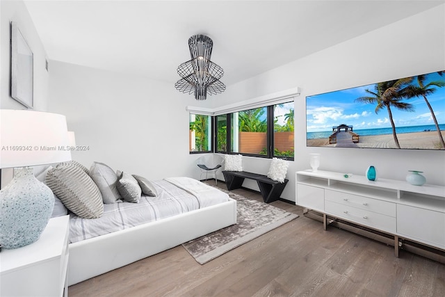 bedroom featuring a notable chandelier and wood-type flooring