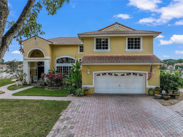 mediterranean / spanish-style house with a garage and a front yard