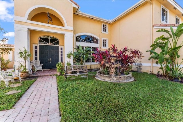 doorway to property featuring a lawn