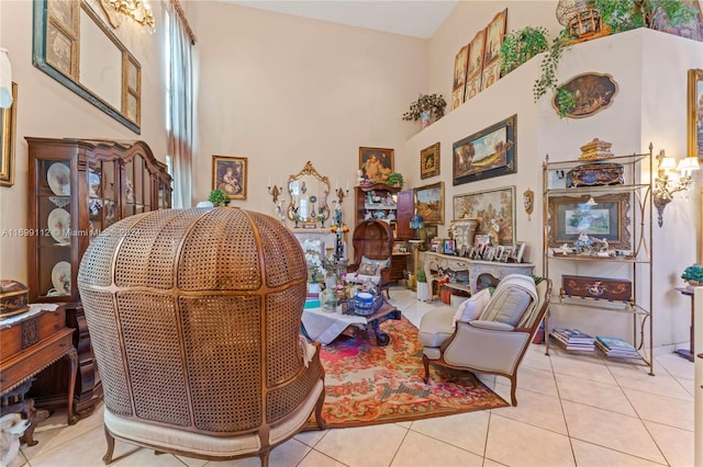 sitting room featuring a towering ceiling and light tile patterned floors