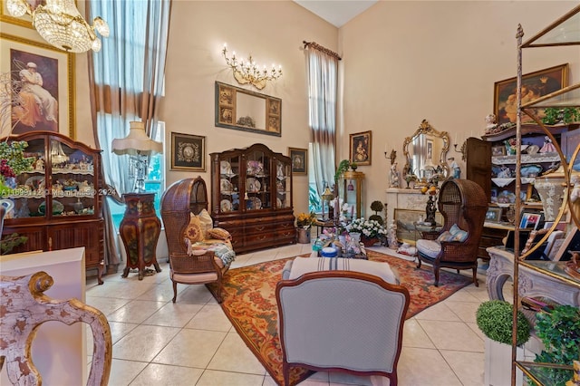 living area featuring light tile patterned flooring, a chandelier, and a high ceiling