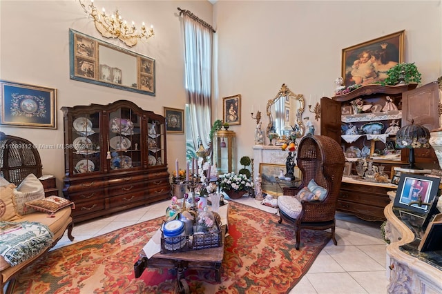 tiled living room featuring a notable chandelier and a high ceiling