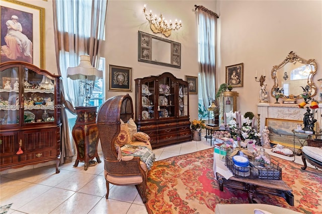 sitting room featuring light tile patterned floors, a high ceiling, and a notable chandelier