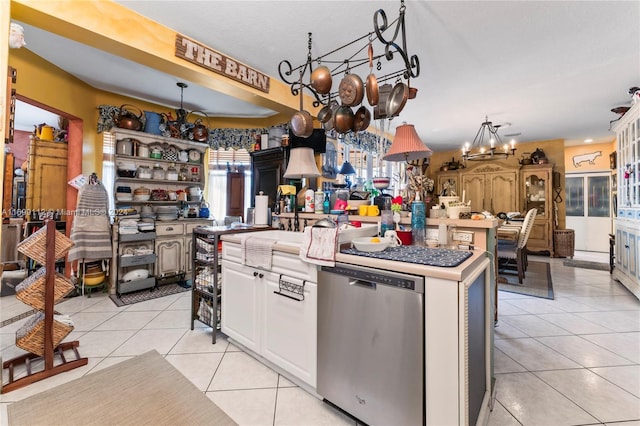 kitchen with a healthy amount of sunlight, a center island, light tile patterned floors, and stainless steel dishwasher