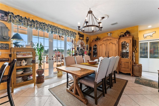 tiled dining room featuring an inviting chandelier