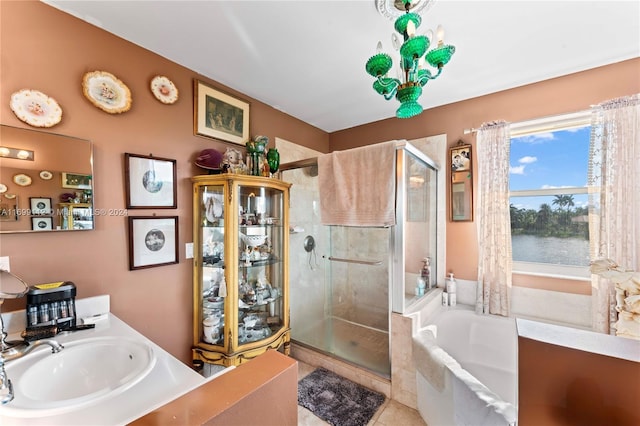 bathroom featuring tile patterned flooring, shower with separate bathtub, vanity, and a water view