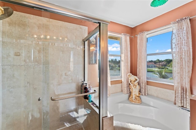 bathroom with shower with separate bathtub and a water view