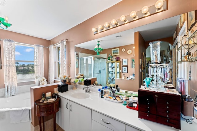 bathroom with vanity and shower with separate bathtub