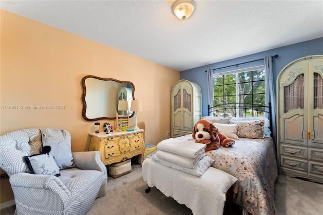 bedroom with light colored carpet and a textured ceiling