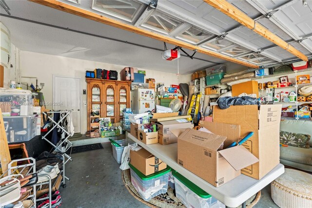 garage with white fridge and a garage door opener